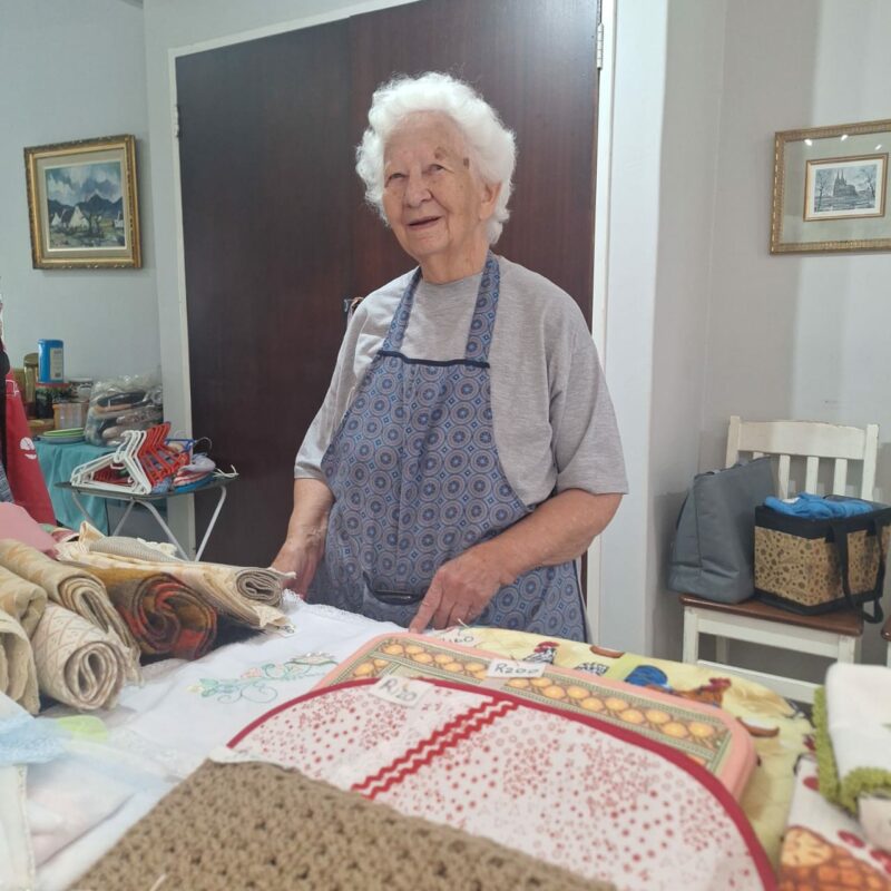 Old woman showing the needlework they have done at the Middelburg SAVF Old Age Home for their bazaar.