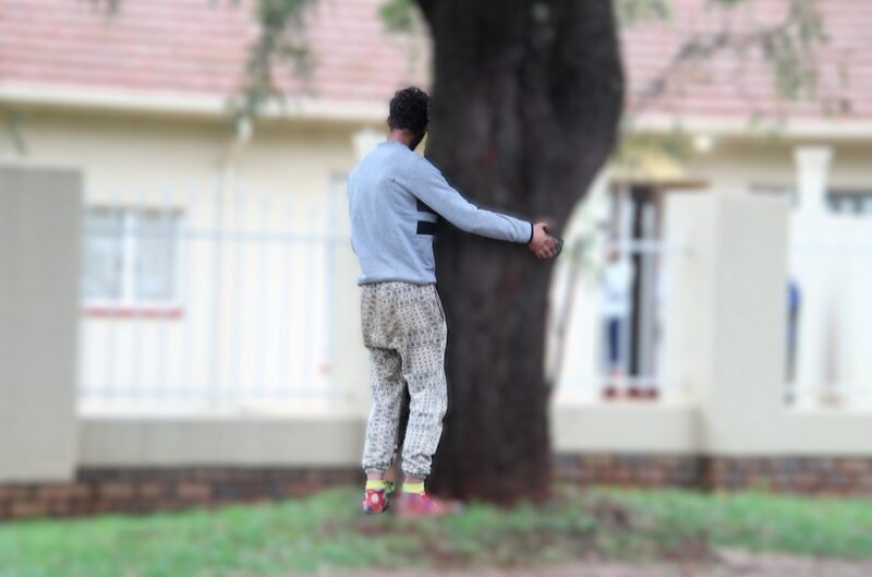 Drug addict hugging a tree.