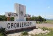 A white welcome sign reads "Welkom / Welcome to Groblersdal," set against a rural landscape with trees and distant hills under a clear blue sky.