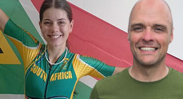 Cyclists Megan Botha and Neville Rosenstein in front of a South African Flag.