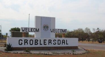 A large welcome sign for Groblersdal, featuring "Welkom" and "Welcome," surrounded by trees and gravel landscaping.
