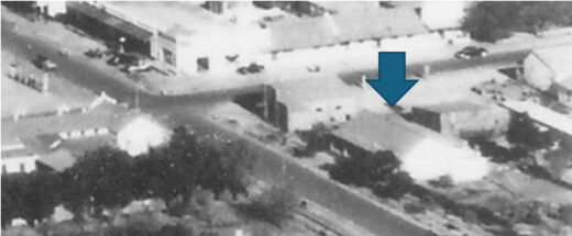 Aerial perspective of the hospital highlighted by a blue arrow pointing to it.