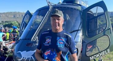 A man standing in front of a helicopter.