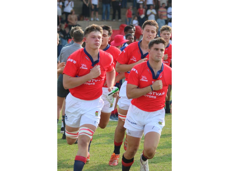 Rugbyspelers draf op die veld.