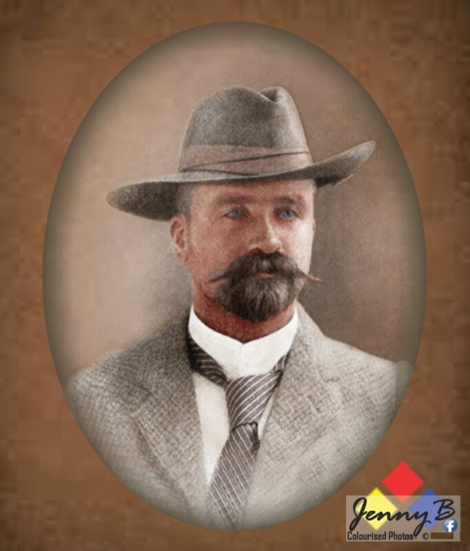 A distinguished man with a curled mustache wears a wide-brimmed hat and a textured suit, gazing confidently. The sepia tone evokes a vintage feel.