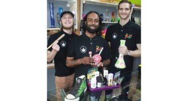 Three men holding cannabis products.