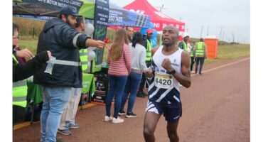 A man running past a water point.