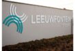 White and teal arch design next to "LEEUWFONTEIN crossing" on a beige wall, with small plants at the base. Emphasis on modernity and calmness.