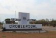 Sign welcoming visitors to Groblersdal, with "WELKOM" and "WELCOME" in bold letters. Surrounded by a dry landscape and trees under a cloudy sky.