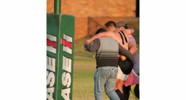 'n Beseerde speler word van die veld af gehelp.