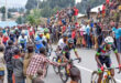 A group of cyclists in colorful jerseys race on a road lined with cheering spectators. The crowd adds vibrancy and excitement to the event.