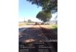 Road construction on N11, South Africa. Workers in orange uniforms operate machinery under a large tree. Clear blue sky, time and GPS data overlay.