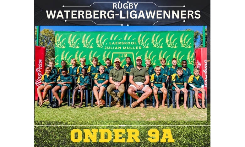 Youth rugby team posing with two adults in front of a green "Laerskool Julian Muller" banner. The team and coaches are smiling, creating a joyful atmosphere.