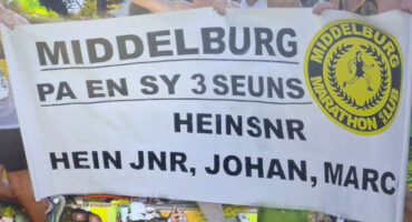 Banner with "Middelburg Marathon Club" logo and text honoring "Pa en sy 3 seuns: Hein Snr, Hein Jnr, Johan, Marc." Background shows marathon runners.