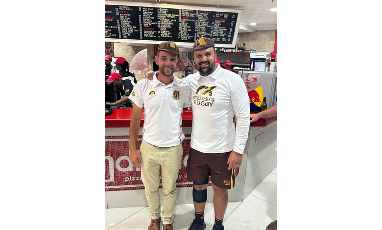 Twee mans glimlag vir die kamera.