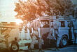 A group of soldiers gathered around a truck, engaged in conversation and examining its features.