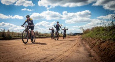 ‘n Klomp fietsryers op ‘n grondpad.