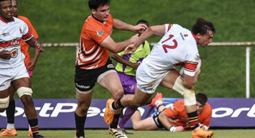 Rugby players engaged in a dynamic match, showcasing teamwork and athleticism on the field.