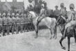 Black and white drawing depicting men riding horses in a dynamic outdoor scene