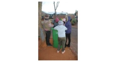 Children gathered at a dustbin.