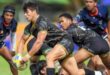 A group of men engaged in a rugby match on a grassy field, showcasing teamwork and athleticism.