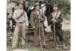 Group of three men in army uniforms, united in service, displaying camaraderie and pride.