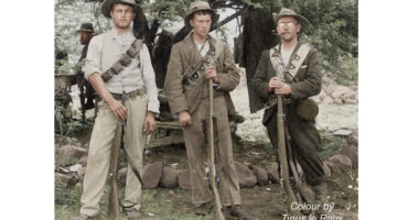 Group of three men in army uniforms, united in service, displaying camaraderie and pride.