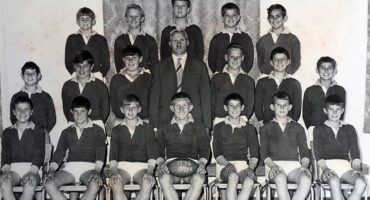 A black and white photo featuring a group of boys posing together, showcasing camaraderie and teamwork.