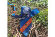 A blue and orange tie casually placed on green grass, showcasing its vibrant colors against the natural backdrop.