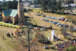 Aerial view of a church surrounded by parked cars, showcasing the building's architecture and surrounding area.