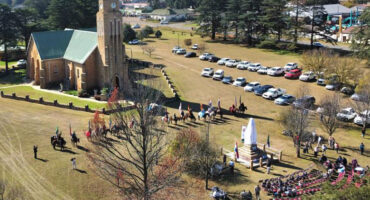 Aerial view of a church surrounded by parked cars, showcasing the building's architecture and surrounding area.