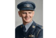 A smiling man in a uniform and cap, exuding a friendly and approachable demeanor.