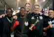 A group of men proudly displaying their boxing trophies while posing for a photo together.