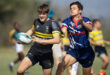 Two young men engage in a rugby match on a grassy field, showcasing athleticism and teamwork.