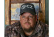 A man dons a camouflage jacket and hat, presenting a blend of style and practicality for outdoor environments.