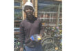 A man is positioned in front of multiple bikes, emphasizing the variety available in the display.