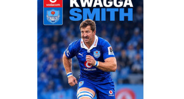 A rugby player sprinting forward while holding the ball, showcasing athleticism and determination on the field.