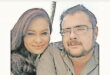 A man and woman smiling together, posing for a photo in a casual setting.
