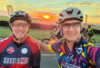 Two men riding bicycles against a backdrop of a vibrant sunset.
