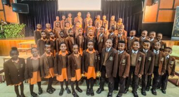 Junior choir of Ermelo English Primary School performing on stage at the Choir Festival held at Ligbron Academy of Technology.