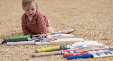 ’n Jong kind kruip tussen ’n ry krieketkolfstokke tydens die sportdag by Laerskool JJ van der Merwe.