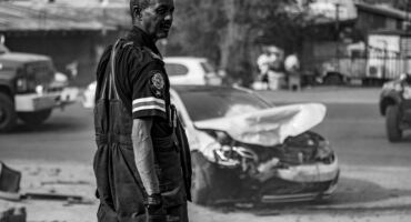 ’n Brandweerman van Msukaligwa Brand- en Reddingsdienste kyk oor sy skouer na die wrak van ’n voertuig na ’n ongeluk in Ermelo se Borderstraat.