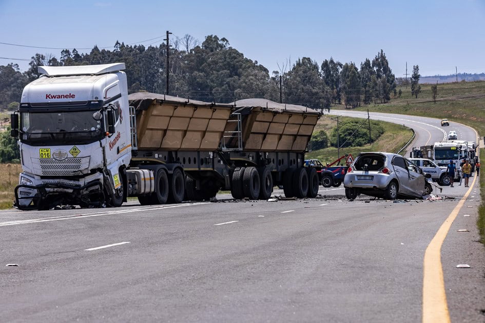 Wide view of the N11 accident scene near Ermelo showing the car wreckage on the right and damaged truck on the left