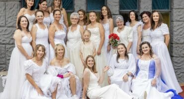 Bruide in hul trourokke en tekkies glimlag tydens die Volle Evangelie Kerk se vrolike “Trourok en Tekkie Tee”