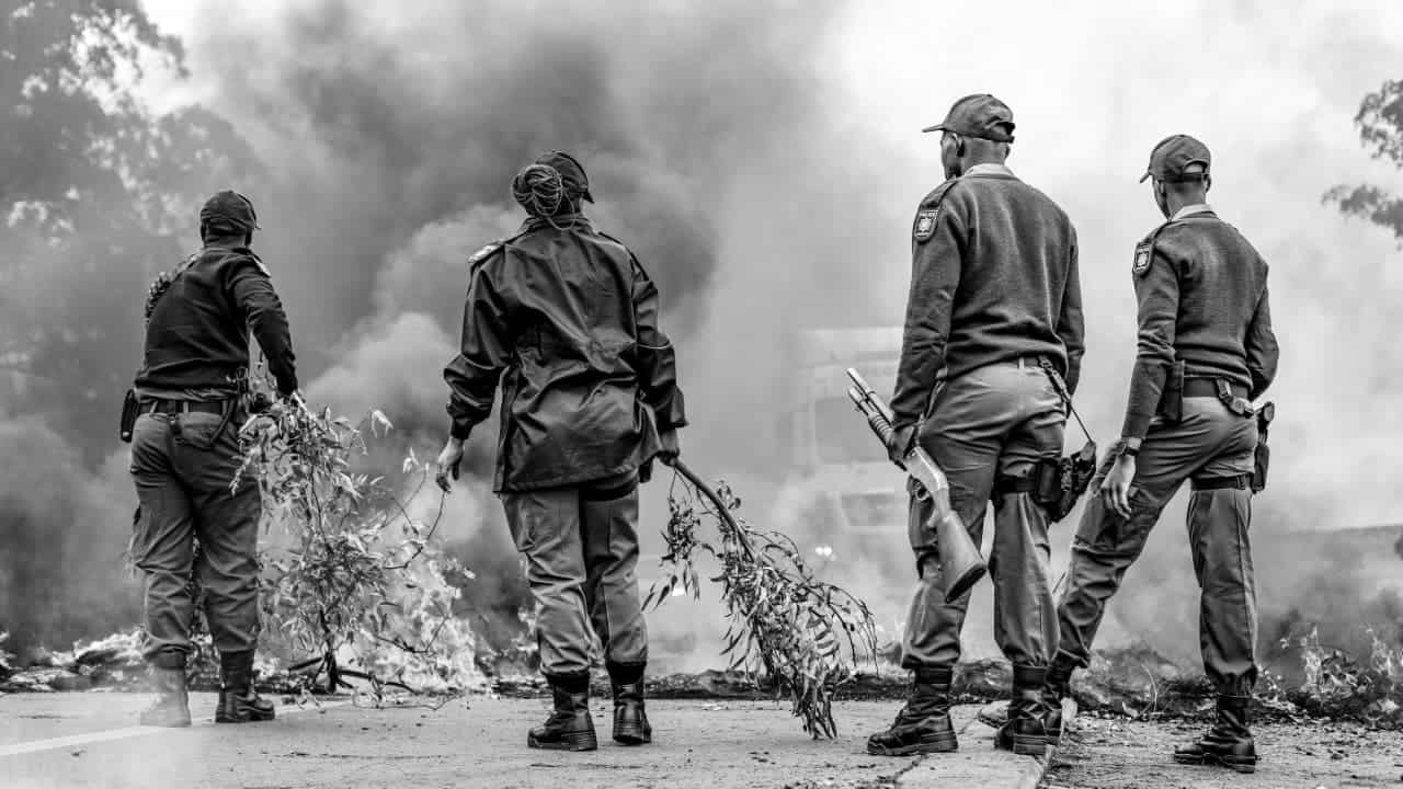 Police officers on the N17 near Ermelo keep watch as others clear the road after protesters were dispersed.