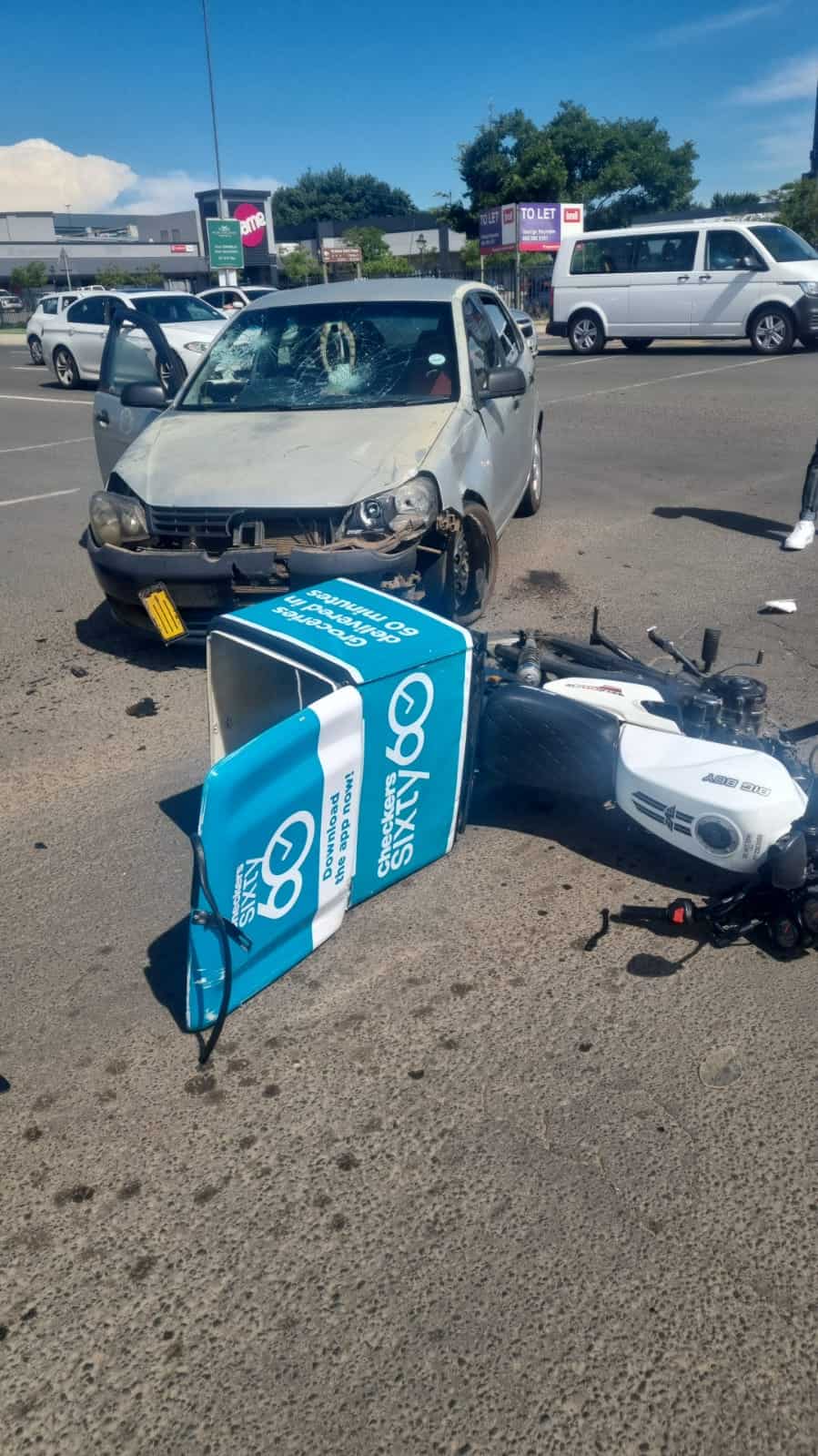 Volkswagen Polo car parked beside a damaged delivery motorcycle, showing damage after a road crash in South Africa.