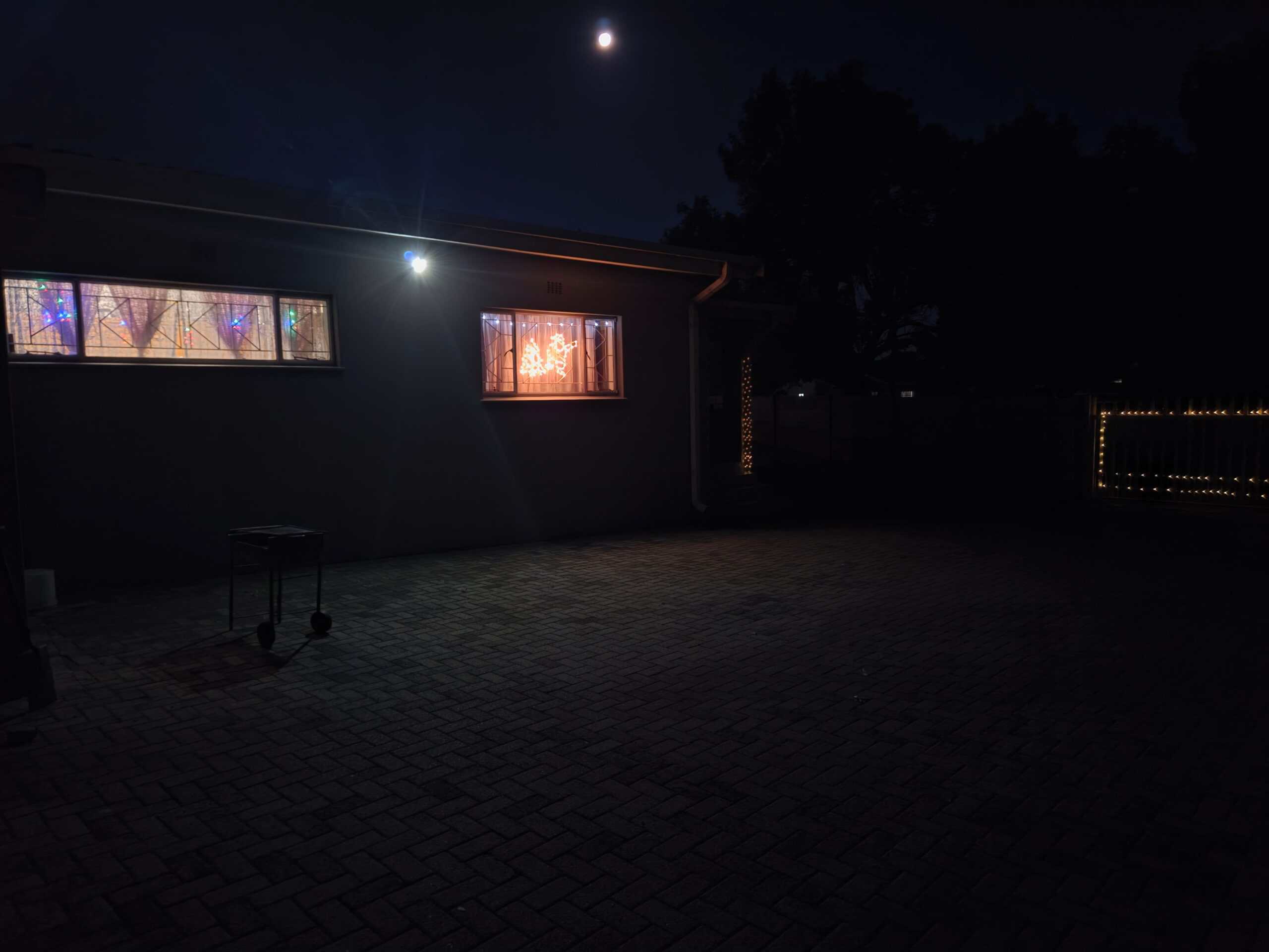 Ermelo-huis met Kersliggies op die motorhek en dekoratiewe versierings in die vensters.