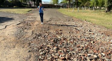 DA-PR-raadslid Amor van der Walt staan op Alkemastraat in Ermelo langs slaggate en verswakte padoppervlak.