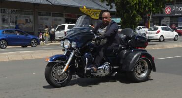 Former Mpumalanga MEC for Community Safety, Vusi Shongwe, riding a motorcycle without a helmet on a public road in Ermelo.