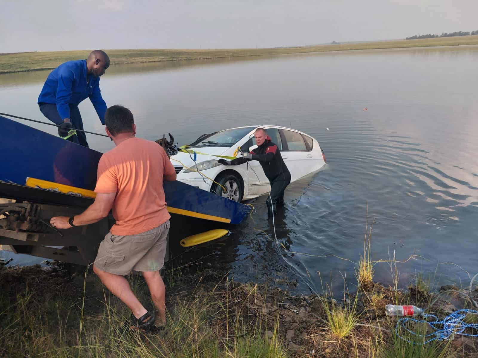 Verskeie rolspelers help om die voertuig, 'n Mercedes A200, uit die water te verwyder.